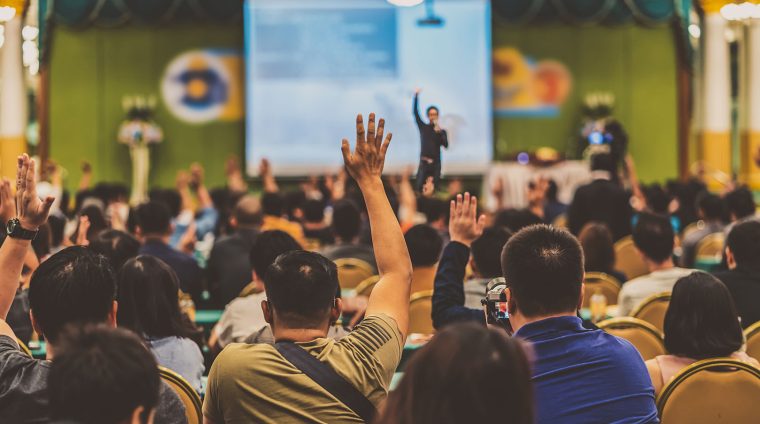 Rear view of Audience showing hand to answer the question from S